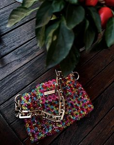 a small purse sitting on top of a wooden table next to a potted plant