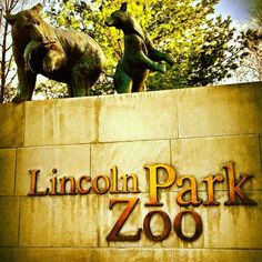 the sign for lincoln park zoo with two statues of elephants standing on top of it