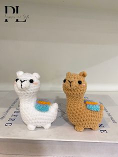 two crocheted llamas sitting on top of each other