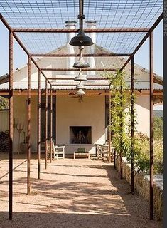 an outdoor covered patio area with chairs and tables under a canopy over the fire place