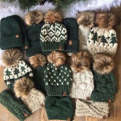 several knitted hats and mittens laid out next to a christmas tree