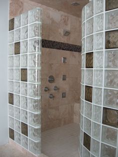 a shower with glass blocks on the wall and tile flooring in front of it