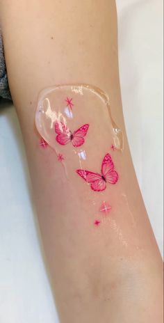 a woman's leg with pink butterflies painted on it and under her arm is shown