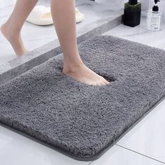 a person standing on a bath mat in the bathroom