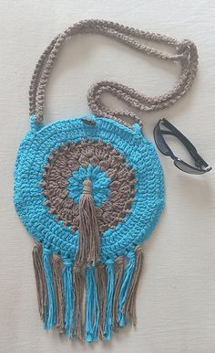 A crochet round bag with tassels.