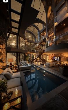 an indoor swimming pool in the middle of a living room with stairs leading up to it