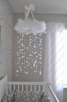 a white crib with a chandelier hanging from the ceiling