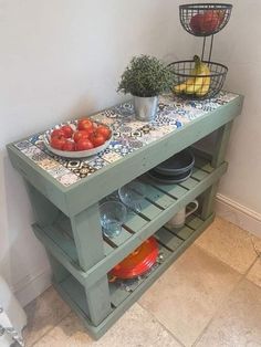 a table with plates and bowls on it next to a potted plant in the corner