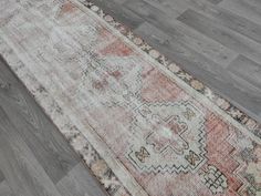 an old rug is laying on the floor in front of a wood flooring area