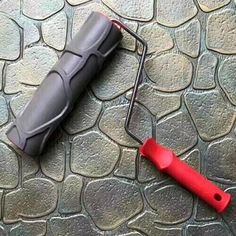 a red and gray umbrella laying on top of a stone floor next to a black handle