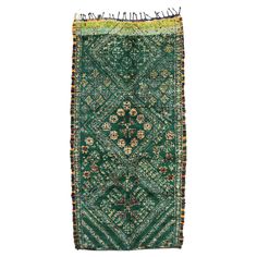 an old green rug with flowers on it