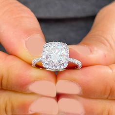 a person holding a diamond ring in their hand