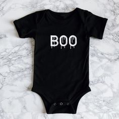 Nothing too spooky about this adorable Halloween onesie, perfect for your October babe. Matches the adult "Bad & Boozy" T-shirt. Comes in Black or White. Recommended Care Instructions Machine wash delicate cycle, cold/warm, inside out with like colors. Remove immediately after washing. Tumble dry on low or hang dry. Do not iron decal. Do not dry clean. Cute Black Cotton Bodysuit, Playful Black Short Sleeve Onesie, Funny Fitted Black Onesie, Unisex Black Short Sleeve Bodysuit, Fitted Cute Black Bodysuit, Cute Fitted Black Bodysuit, Fun Black Cotton Onesie, Cute Black Onesie With Letter Print, Playful Fitted Black Onesie