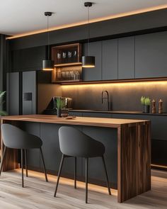 a kitchen with two chairs and an island in front of the counter, next to a potted plant