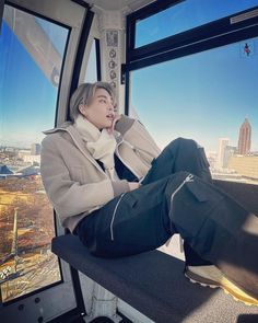 a man sitting on top of a bus looking out the window