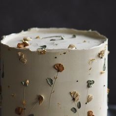 a close up of a cake with flowers on the frosting and gold sprinkles