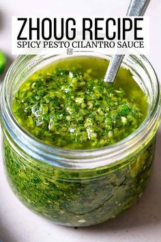 a jar filled with pesto sauce on top of a table