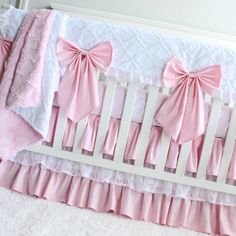 a crib bed with pink bows on it