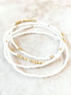 Dainty White Bracelet With Gold Beads, Dainty White Stretch Bracelet With Gold Beads, Flexible White Bracelets With Colorful Beads, Dainty White Heishi Beads Bracelet, Adjustable White Beaded Bracelets With Gold Beads, White Dainty Bracelet With Faceted Beads, Dainty White Bracelets With Faceted Beads, Dainty White Bracelet With Faceted Beads, Dainty White Round Beads Stretch Bracelet