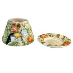 two plates with birds and flowers on them, one has a saucer in the shape of a bowl