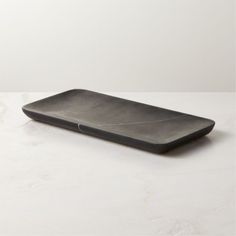 an empty black tray on a white table