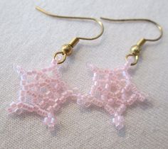 two pink beaded stars are hanging from gold earwires