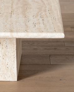 a white marble bench sitting on top of a hard wood floor