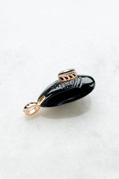 Agate Mussel with Diamond Charm from Dezso by Sara Beltran Hand-carved line agate in the shape of a mussel shell Raised center diamond set in black enamel and 18K gold 18k gold bale with black fin enamel Charm measures approximately 1" length (including bale) x 0.3" width Hand-carved in Jaipur, India Elegant Carved Agate Jewelry, Black Oval Agate Jewelry, Black Intaglio Jewelry As A Gift, Elegant Engraved Agate Jewelry, Mussel Shell, Diamond Charm, Enamel Charms, Jaipur India, Diamond Set