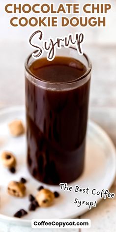 chocolate chip cookie dough syrup in a glass on a white plate with cookies around it