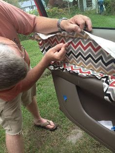 an older man opening the back door of a car to check on his new seat cover