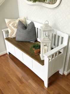 a white bench with some pillows on it