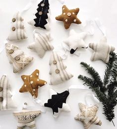 christmas ornaments are arranged on a white surface and decorated with black, gold, and white fabric