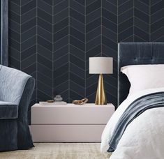 a bedroom with black and gold wallpaper, two chairs and a white nightstand in front of the bed