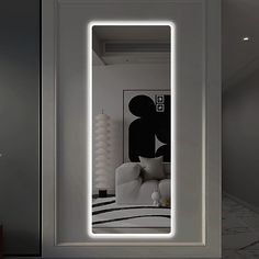 an illuminated mirror in the corner of a room with a white couch and black and white artwork