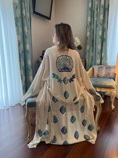 "Beautiful handmade long white Phoenix bird celestial print kimono robe, designed with cotton fabric, it flows as you move for a comfortable wear. Beach cover up, a kimono with Phoenix bird.  Beach cover-up, a kimono with an evil eye design.   This is a lovely, good-quality kimono, with traditional breathable kimono sleeves.        A belt that ties around the waist. Great to wear around the house, on beaches, or to dress up with some jeans & a T-shirt, covering up on the beach with a swimsuit.         We love kimonos as they are so versatile. They also make really special & unique birthday, valentines Day, Christmas gifts, and Mother's Day gifts. The perfect combination of comfort and style, this kimono is a great addition to your new season wardrobe.    Cotton Fabric and Handmade      Len Celestial Print, Evil Eye Design, Phoenix Bird, Unique Birthday, Kimono Sleeves, Boho Kimono, Print Kimonos, Womens Robes, Kimono Cardigan