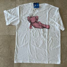 Uniqlo Kaws Unisex White And Pink Short Sleeve T-Shirt In Size M. Uniqlo And Kaws Have Done It Again And Collaborated To Create These Unique Limited Edition Design Tees. Material: 100% Cotton Measurement: Armpit To Armpit 21” Top To Bottom 27.5” Casual White Pre-shrunk Shirt, Uniqlo Graphic Tee With Graphic Print, Uniqlo Graphic Print T-shirt, Uniqlo Graphic Tee For Streetwear, White Cotton Shirt With Front Print, White Short Sleeve Top With Front Print, Casual White Print Short Sleeve Shirt, White Cotton Top With Front Print, Uniqlo Crew Neck Graphic Print Tops