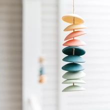 a wind chime hanging from a string with different colored rocks on it's side