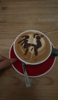 a cup of cappuccino with an image of two people in the foam