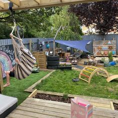 a man is sitting on a hammock in his backyard