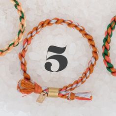 three different colored cords with one number five on it and the other has a tassel