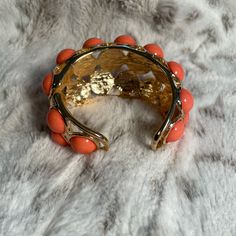 Fabulous Vintage Kenneth Jay Lane Gold Tone Faux Coral Cabochon Clamper Bracelet. Available For Purchase Is A Fabulous Vintage Signed Kenneth Jay Lane Chunky Gold Tone Faux Coral Cabochon Clamper Cuff. The Bracelet Itself Is Stamped Kenneth Lane On The Inside And Is A Heavy Costume Gold Tone Metal. It’s Got Several Fabulous Large Faux Coral Lucite* Cabochons Intact. The Bracelet Itself Shows No Signs Of Discoloring Or Usage By Any Means, It’s In Stunning Vintage Condition, Clamper Opening Is In Spring Formal Cuff Jewelry, Jeweled Bangle Cuff Bracelet, Adjustable Coral Jewelry For Parties, Spring Formal Metal Bracelets, Elegant Orange Jewelry For Spring, Elegant Orange Spring Jewelry, Elegant Orange Metal Bracelets, Red Metal Cuff Bracelet, Antique Gold Cabochon Bracelets