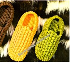 two crocheted slippers sitting next to each other on top of a fur rug