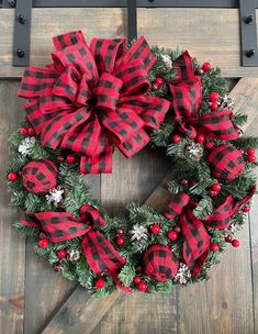 a red and black wreath on a wooden door