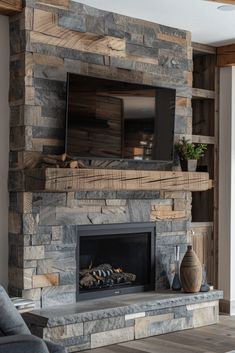 a living room with a large stone fireplace and television mounted on it's wall