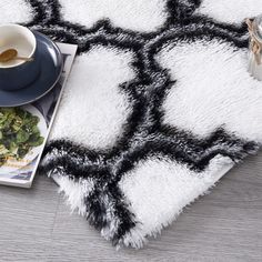 a cup of coffee on top of a white and black rug