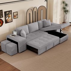 a living room scene with focus on the sectional sofa and ottoman, along with pictures on the wall