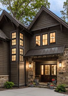 a large brown house with lots of windows on it's sides and stone pillars