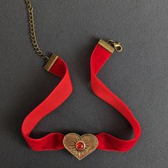 Bronze Heart Pendant on Red Velvet Ribbon Choker Capture the essence of timeless romance with this Bronze Heart Pendant elegantly set on a rich Red Velvet Ribbon Choker. This Vintage Style Red Necklace exudes charm and sophistication, featuring a Romantic Heart Charm that makes it an ideal Embellished Choker for any special occasion. The intricately designed bronze heart pendant offers a touch of antique allure, beautifully complemented by the luxurious red velvet ribbon. The combination of vint Red Velvet Ribbon, Ribbon Choker, Ribbon Jewelry, Romantic Heart, Vintage Ribbon, Red Necklace, Valentines Gift, Velvet Ribbon, Memorable Gifts