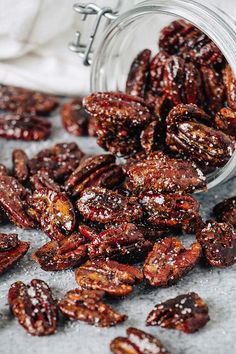 a glass jar filled with raisins sitting on top of a white table cloth