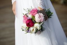 a bride holding a bouquet of flowers in her hand